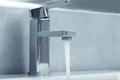 Photo of Stream of water flowing from tap in bathroom