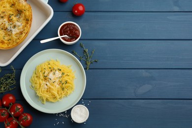 Photo of Tasty spaghetti squash with cheese and thyme served on blue wooden table, flat lay. Space for text