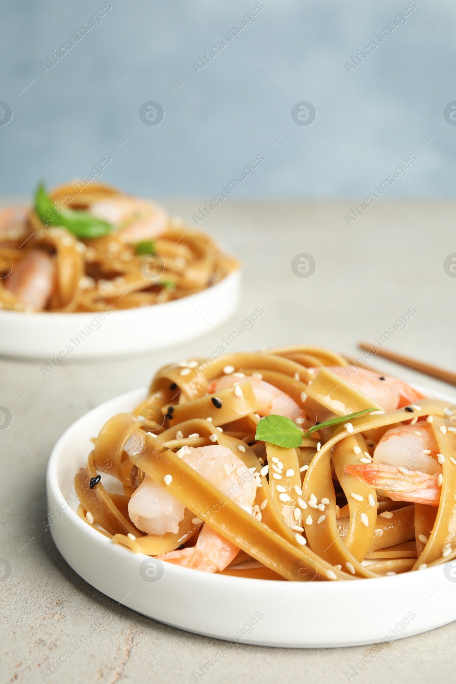 Photo of Tasty buckwheat noodles with shrimps served on light table