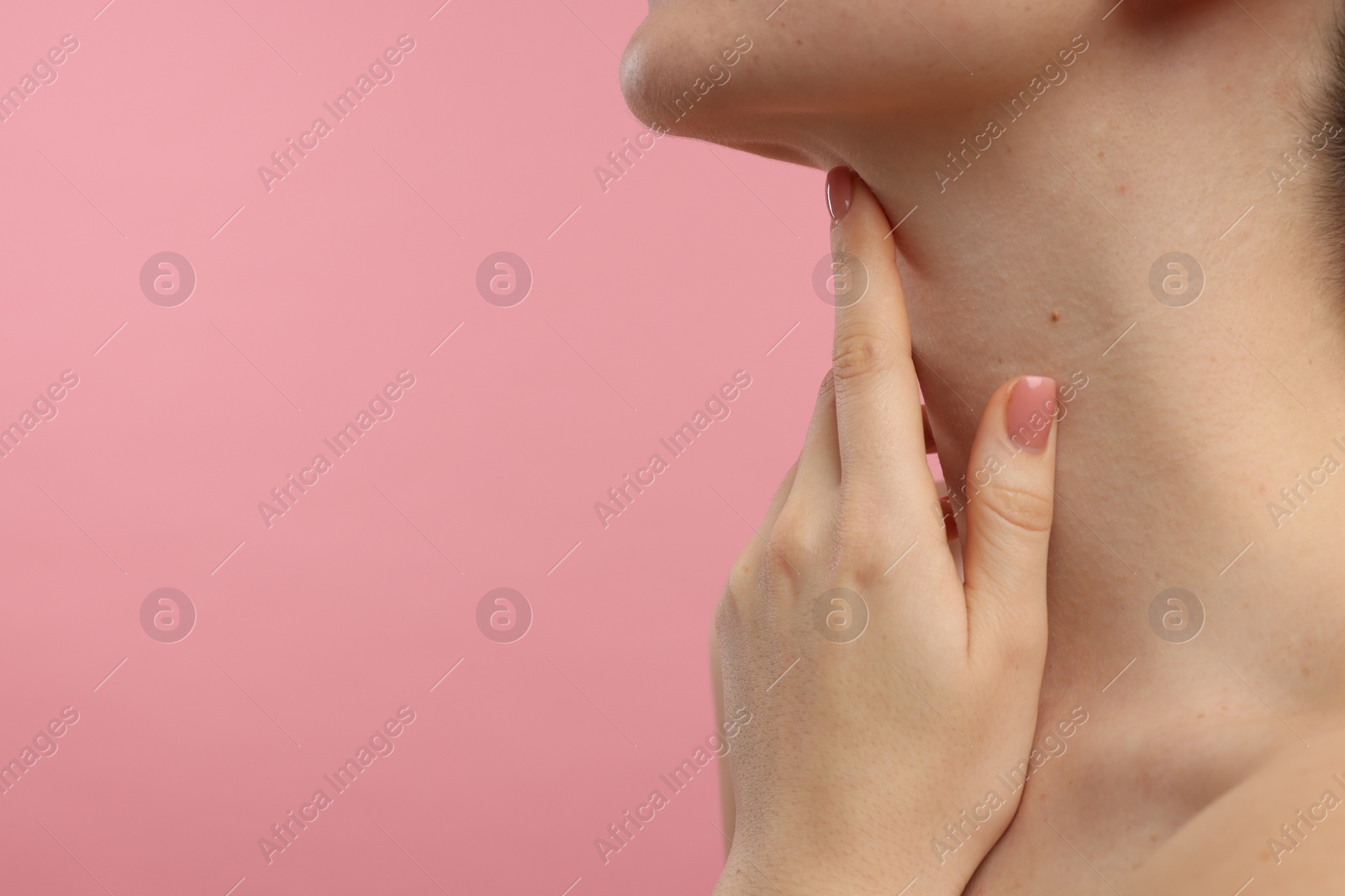 Photo of Woman touching her neck on pink background, closeup. Space for text