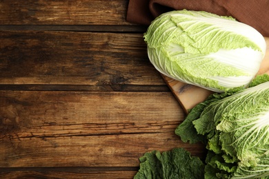 Photo of Fresh ripe Chinese cabbages on wooden table, flat lay. Space for text