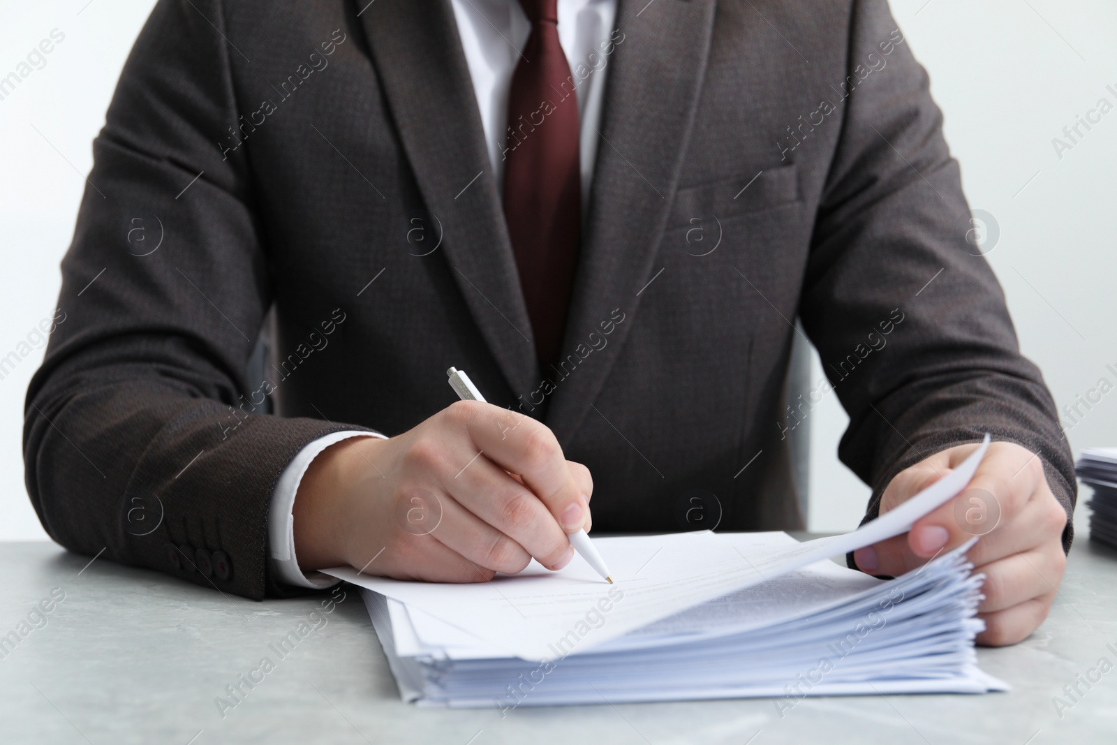 Photo of Man signing document at table in office, closeup