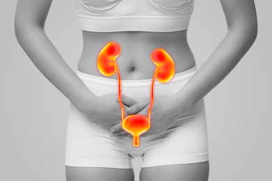 Image of Woman suffering from cystitis on light grey background, closeup. Illustration of urinary system