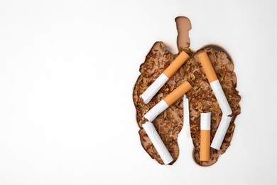 Photo of No smoking concept. Top view of dry tobacco and cigarettes through burned lungs shaped paper, space for text