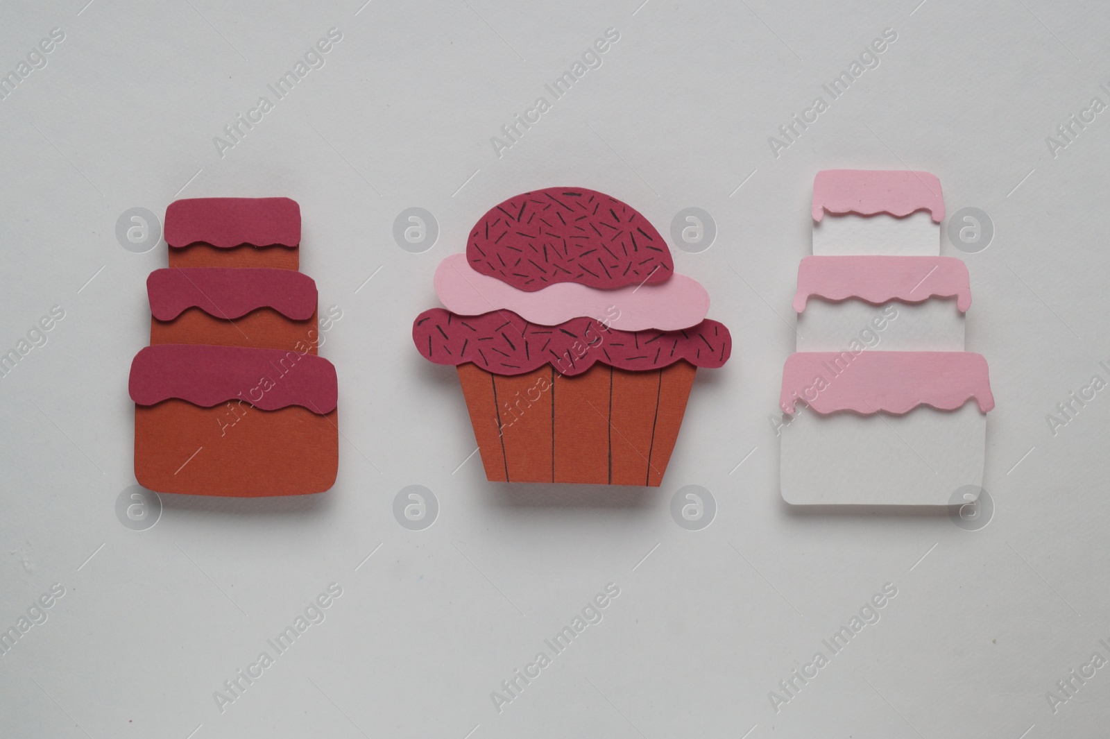 Photo of Different birthday cakes on white background, flat lay