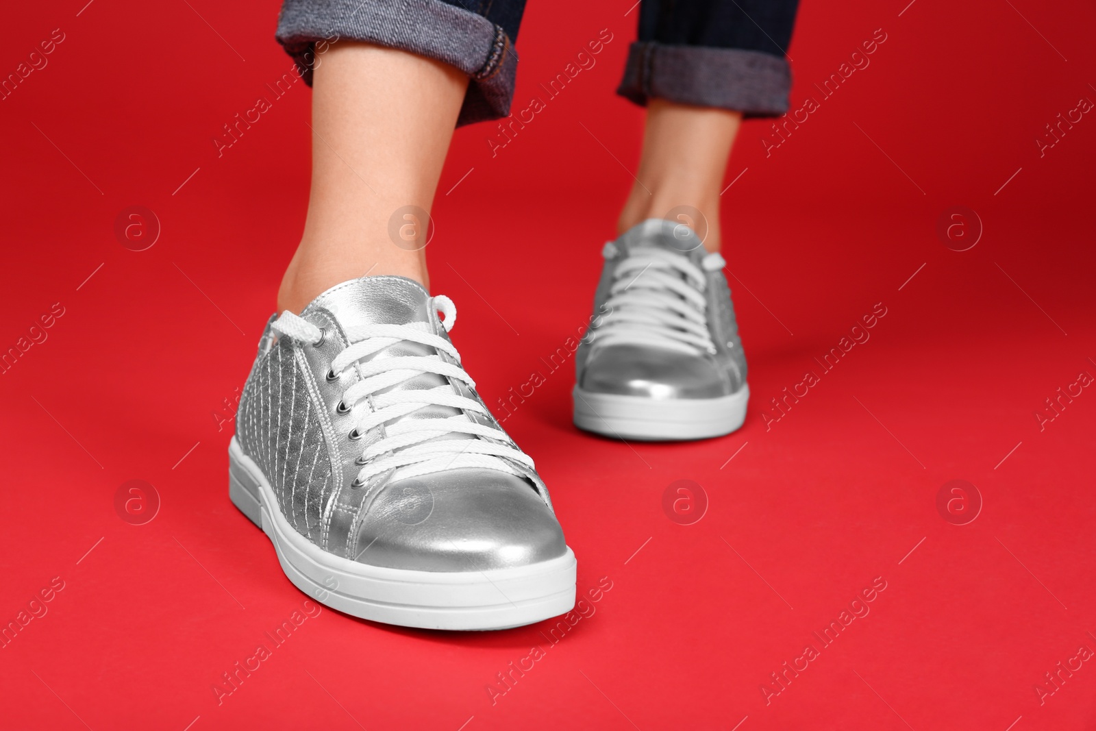 Photo of Woman in stylish sport shoes on color background