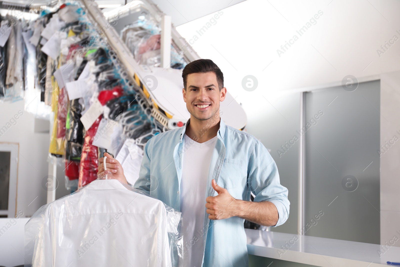 Photo of Happy client with shirt at modern dry-cleaner's