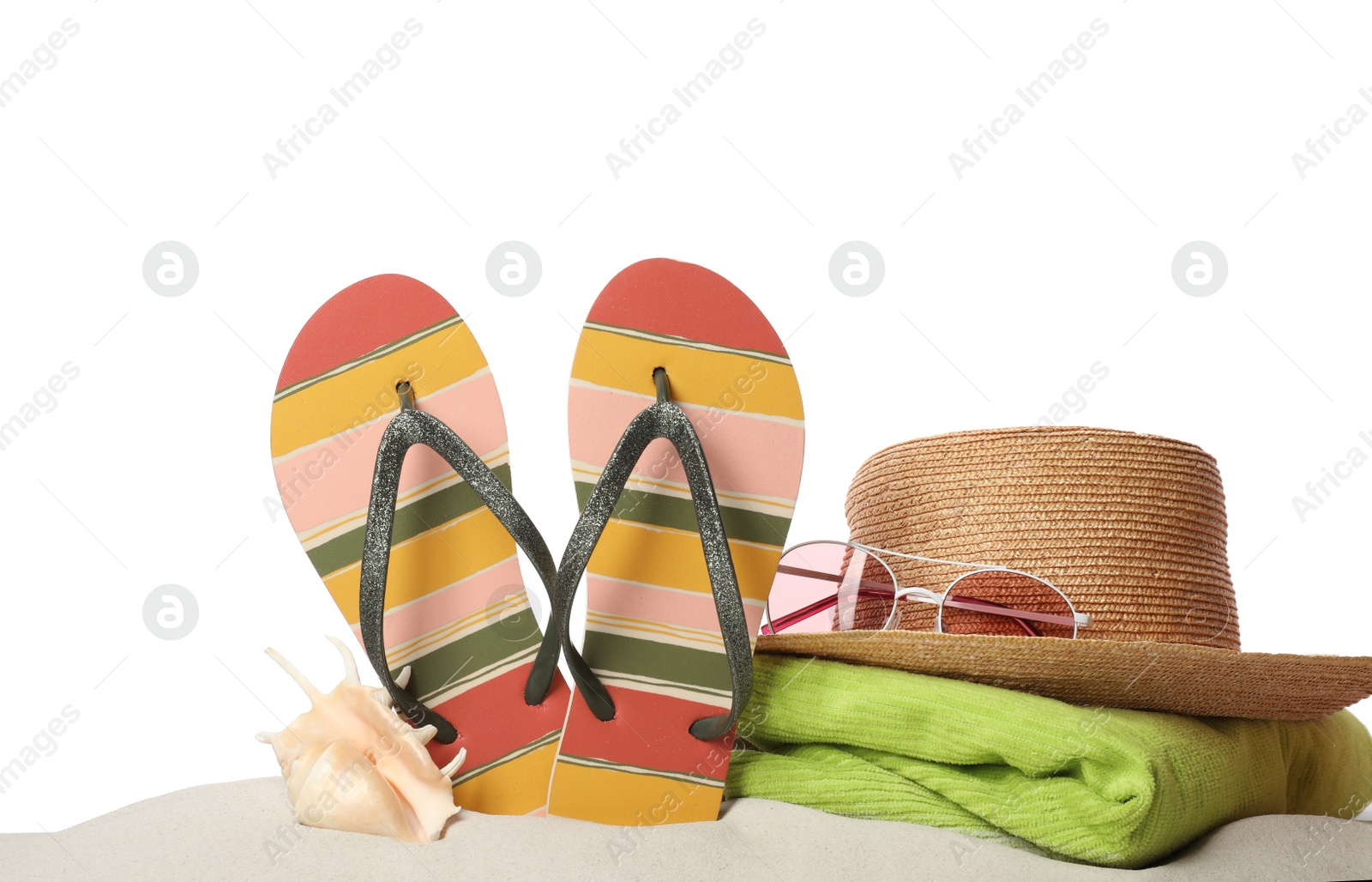 Photo of Different stylish beach accessories on sand against white background