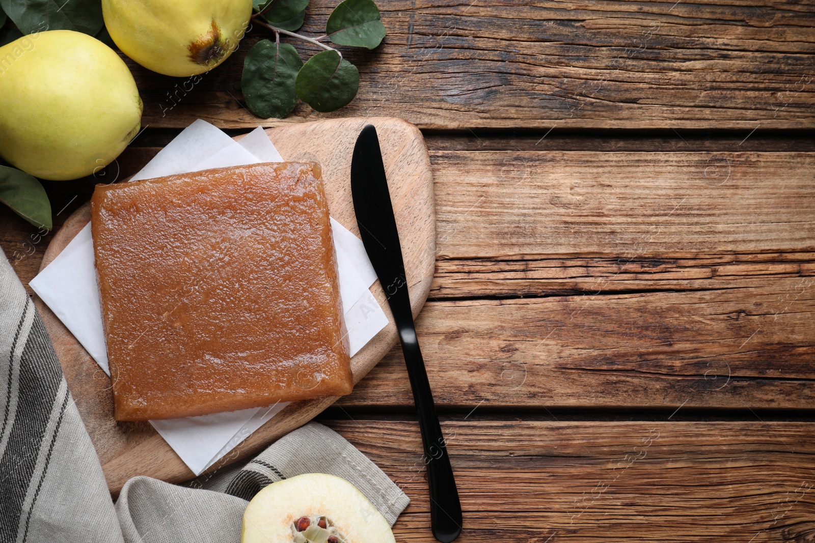 Photo of Delicious quince paste and fresh fruits on wooden table, flat lay. Space for text