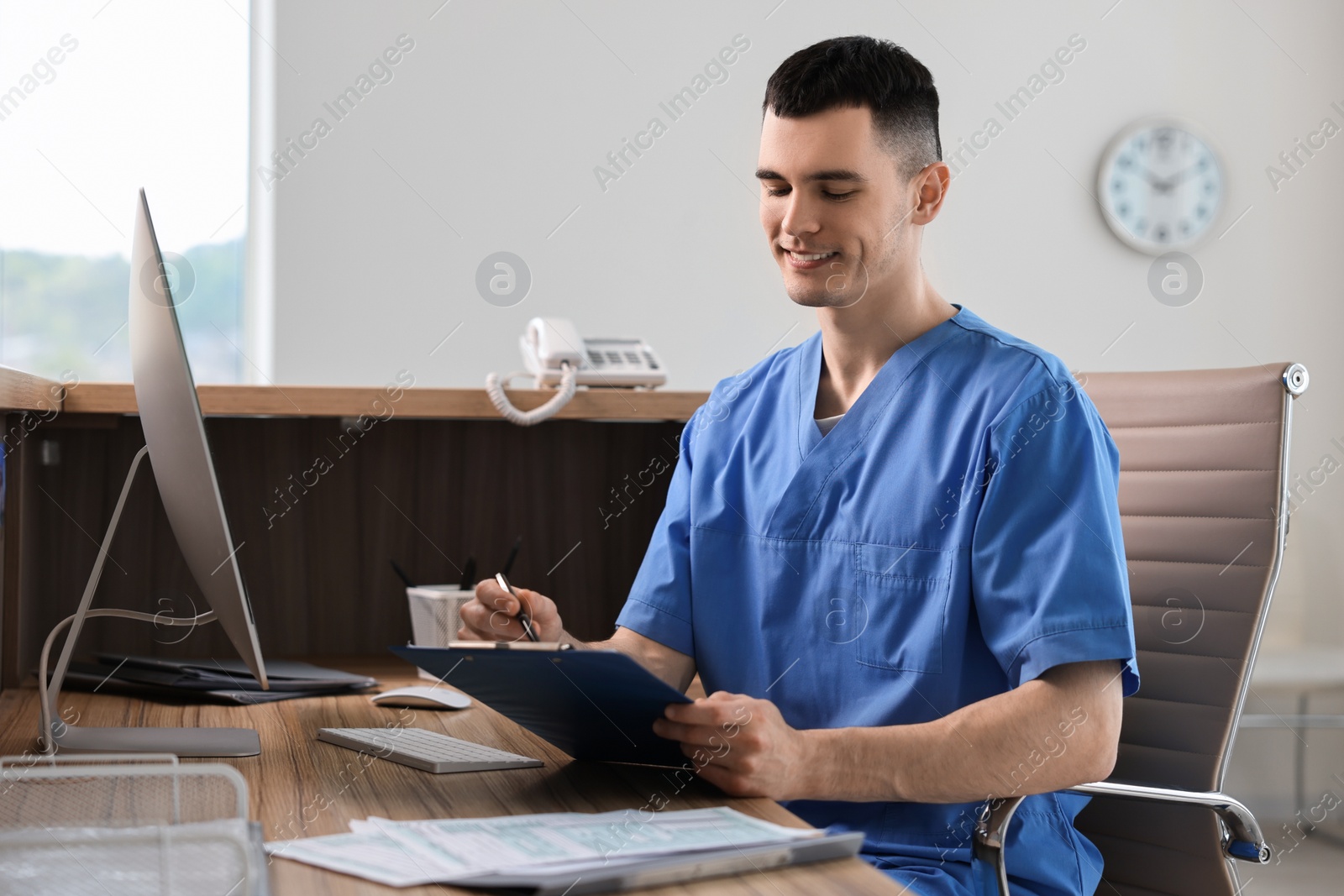 Photo of Smiling medical assistant working at hospital reception