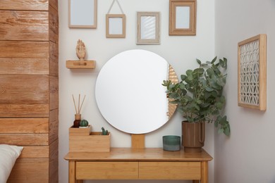 Stylish dressing table and mirror near white wall indoors. Interior design