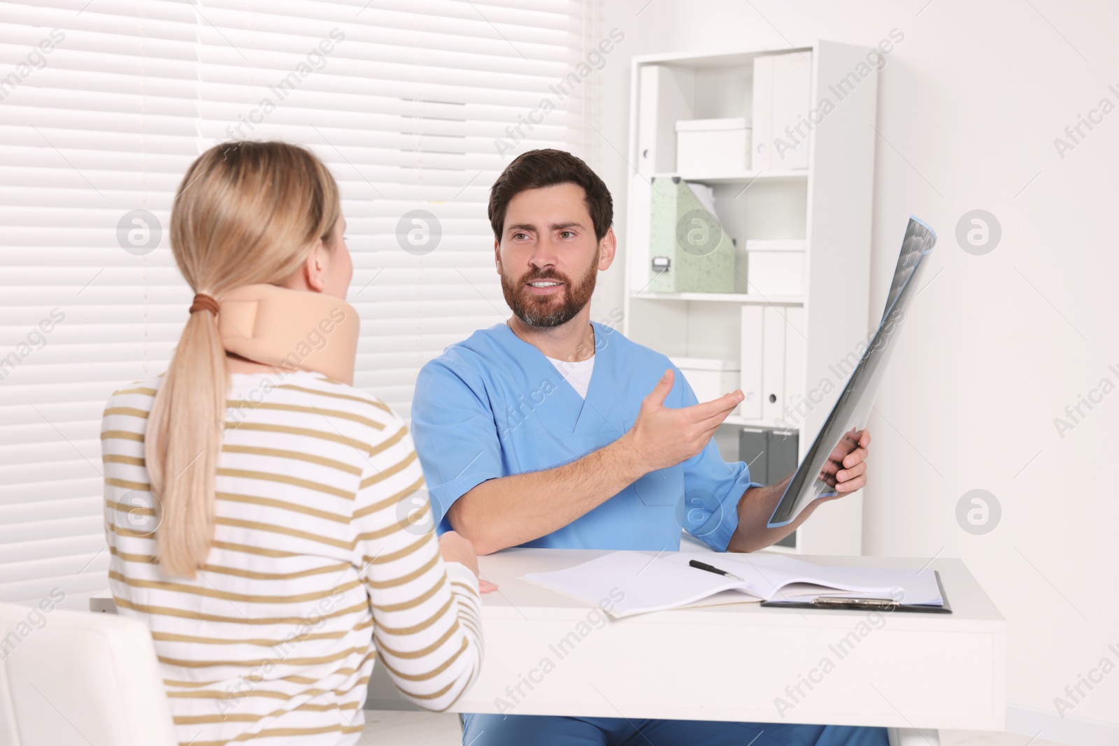 Photo of Doctor with neck MRI scan consulting patient in hospital