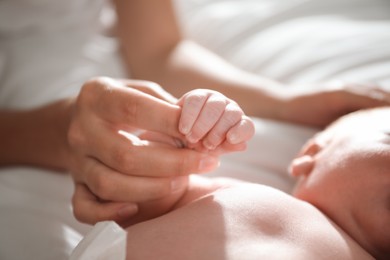 Photo of Mother with her newborn baby, closeup on hands