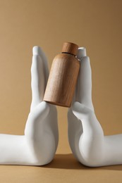 Composition with wooden bottle of cosmetic product on dark beige background