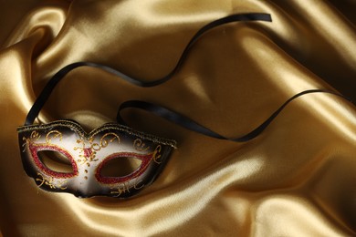Photo of Elegant face mask on golden fabric. Theatrical performance