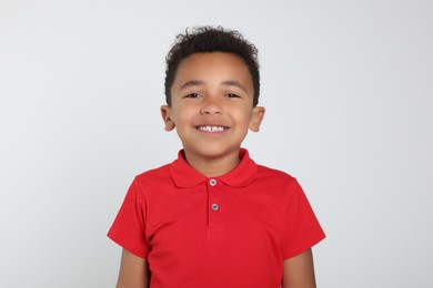 Photo of Portrait of cute African-American boy on light grey background