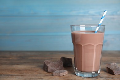 Photo of Delicious chocolate milk on wooden table. Space for text