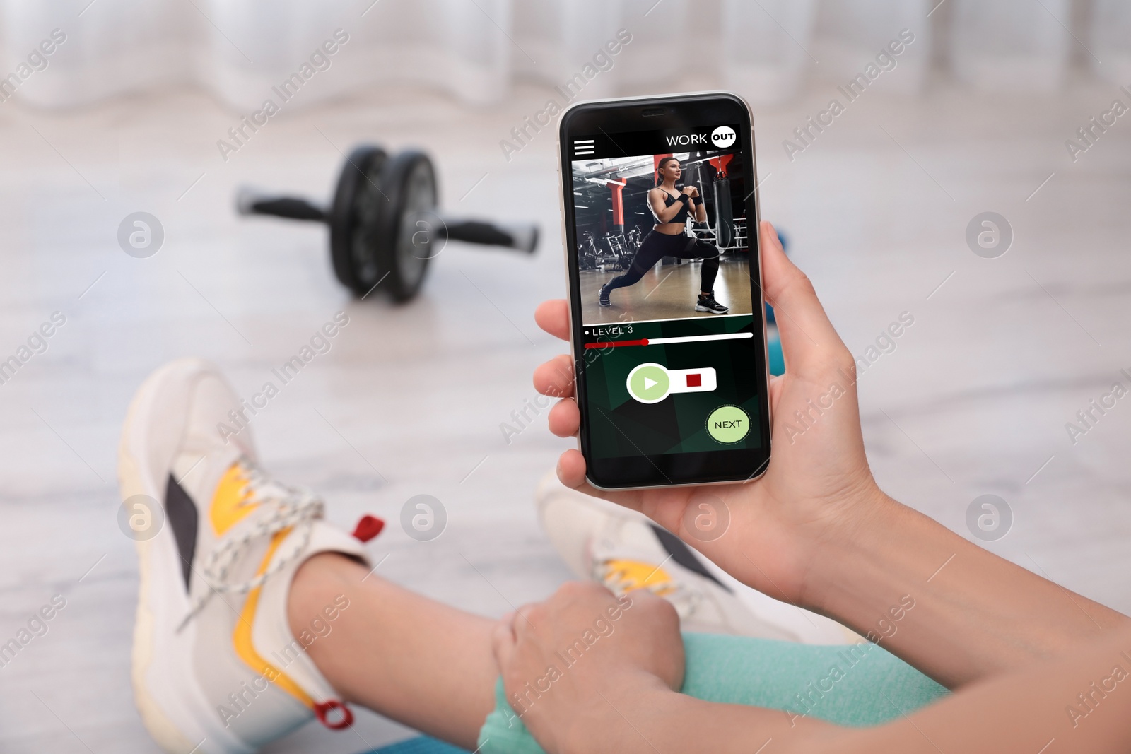 Image of Woman having workout with personal trainer via smartphone at home, closeup