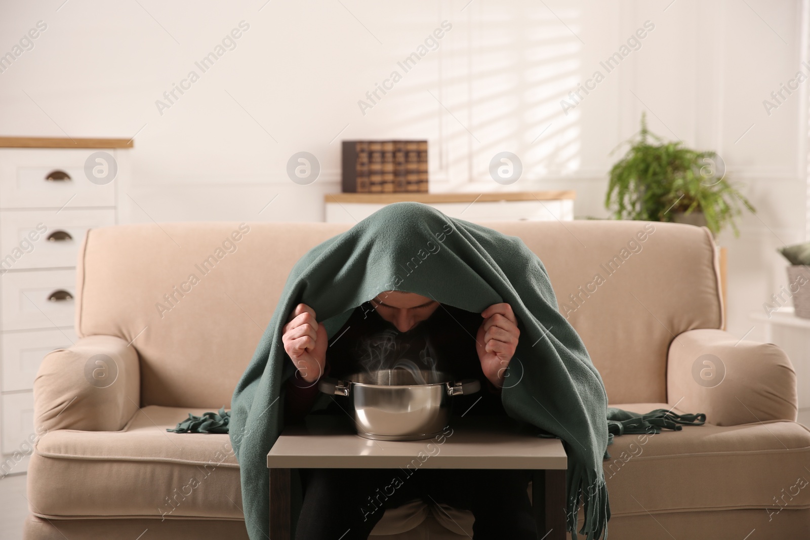 Photo of Man with plaid doing inhalation at table indoors