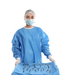 Photo of Doctor near table with surgical instruments on light background