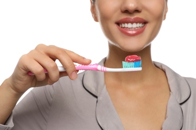 Woman holding toothbrush with paste on white background, closeup