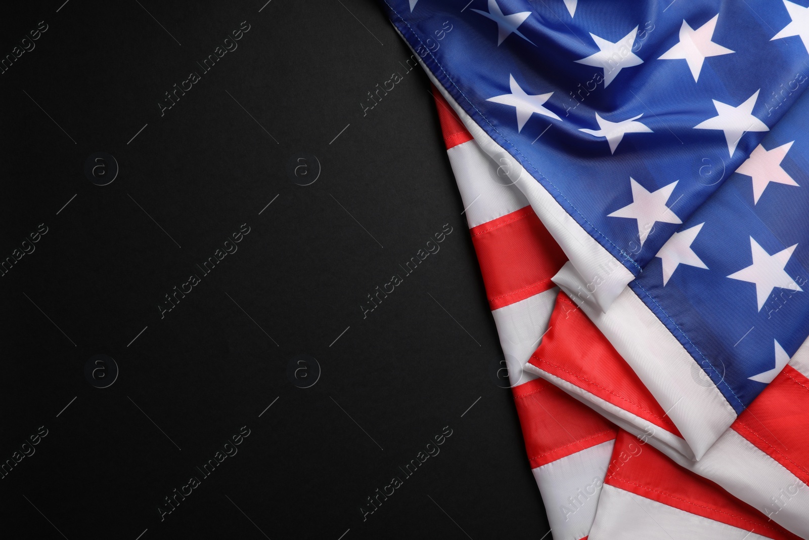 Photo of USA flag on black background, top view. Space for text