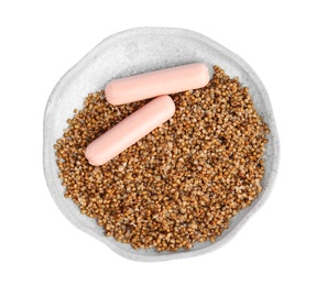 Delicious buckwheat porridge with sausages on white background, top view