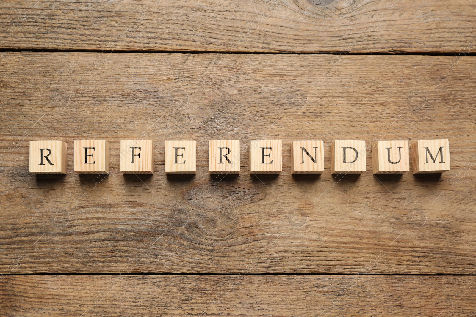 Photo of Word Referendum of cubes on wooden table, flat lay