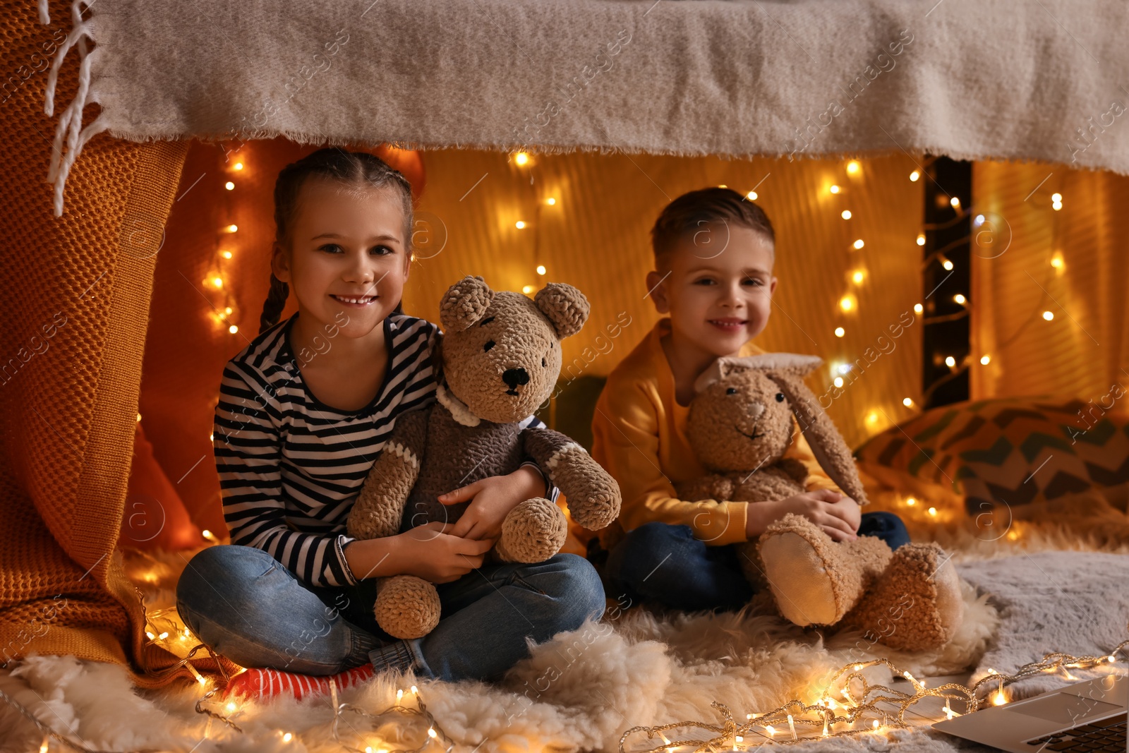 Photo of Kids with toys playing in decorated play tent at home