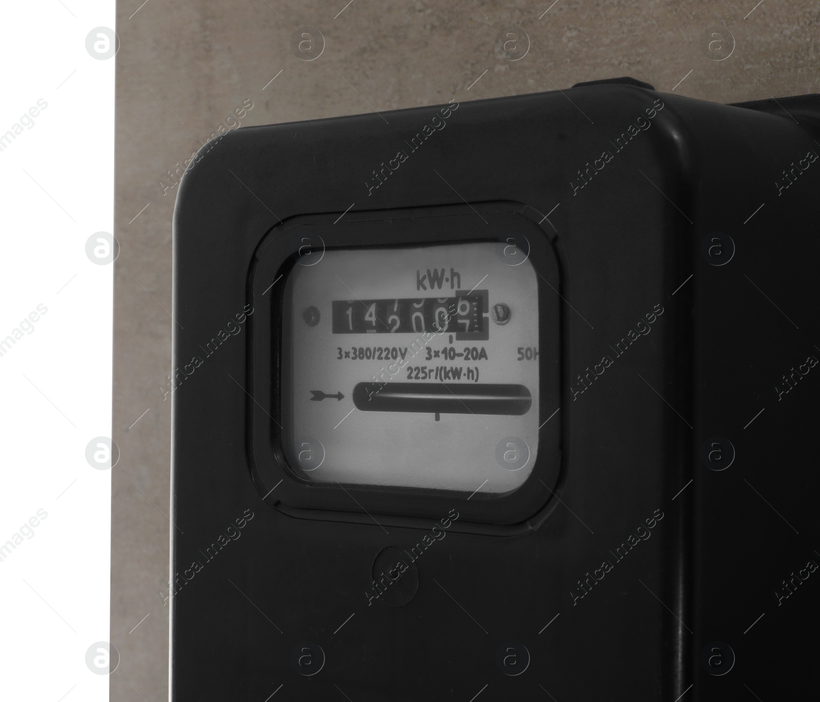 Photo of Electricity meter on light grey wall against white background, closeup. Space for text