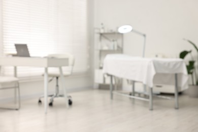 Photo of Blurred view of dermatologist's office with examination table