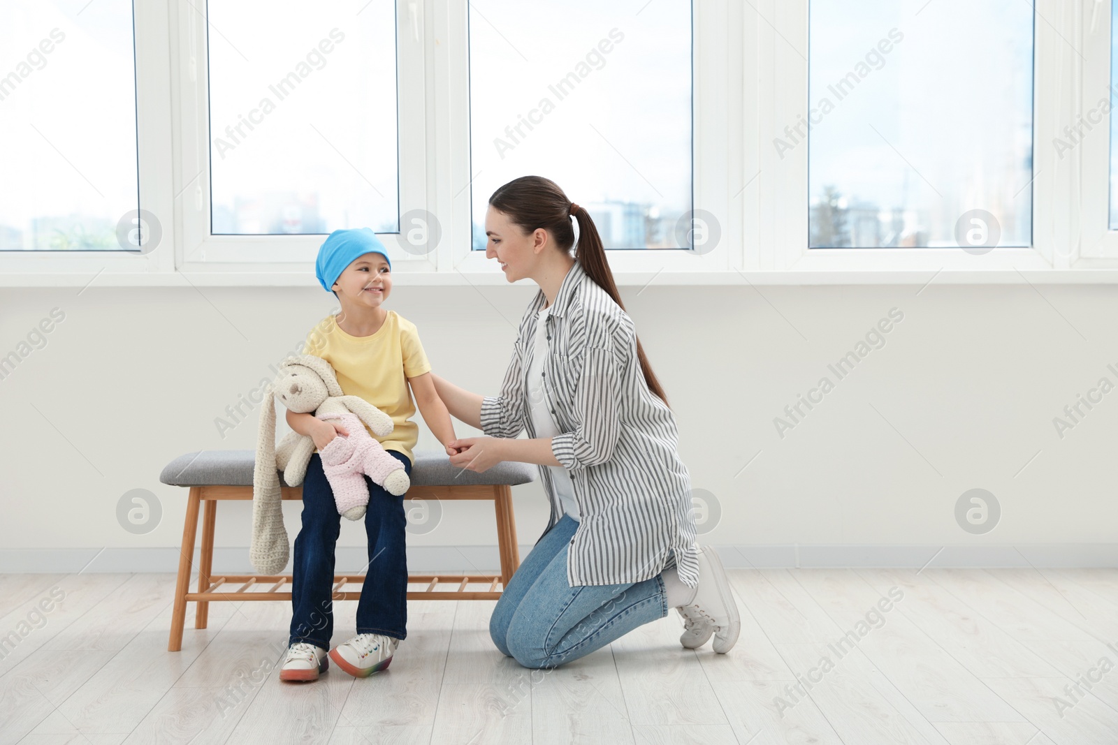 Photo of Childhood cancer. Mother and daughter with toy bunny in hospital