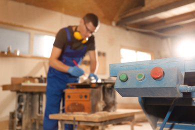 Photo of Control panel of machine and blurred carpenter on background