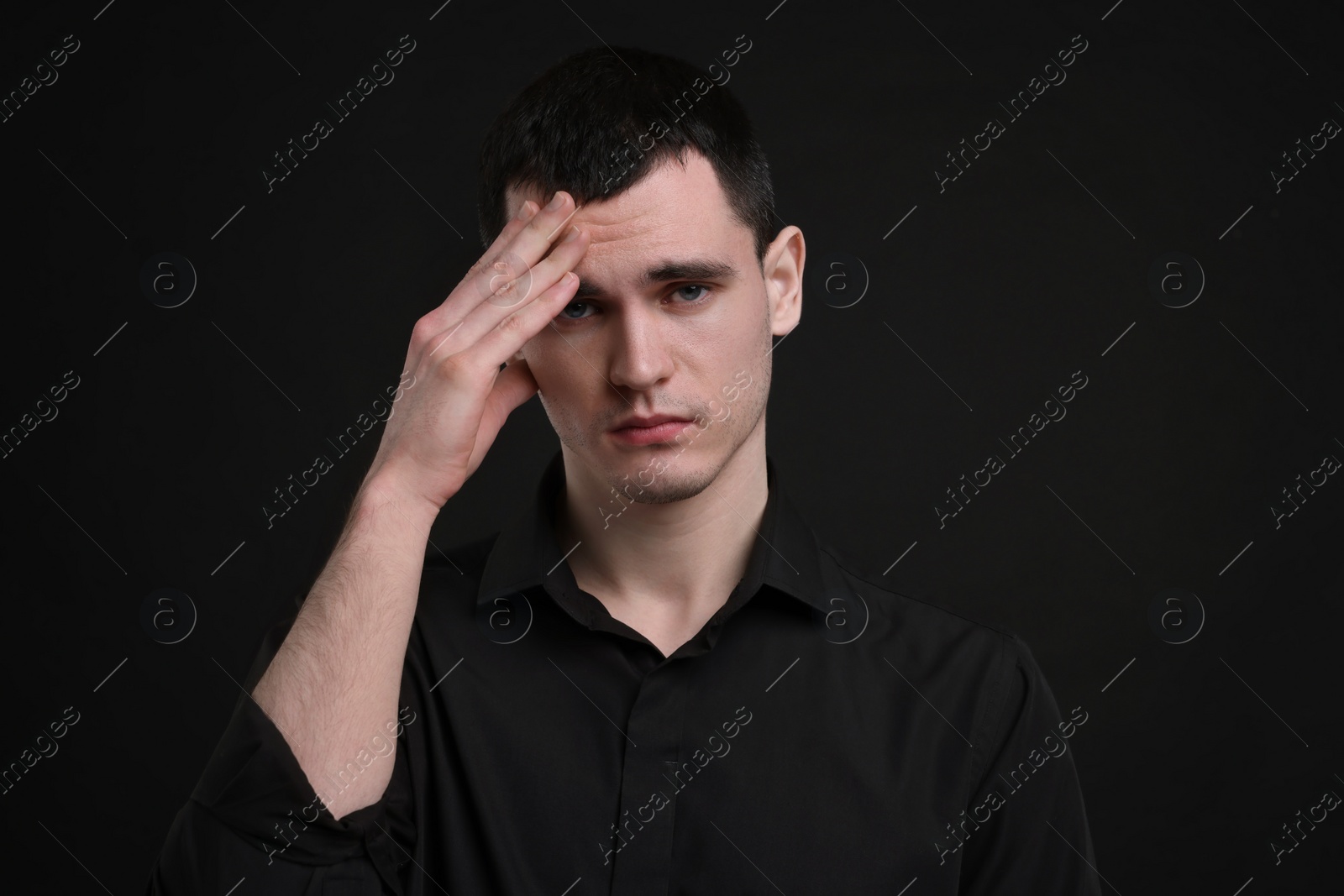 Photo of Portrait of sad man on black background