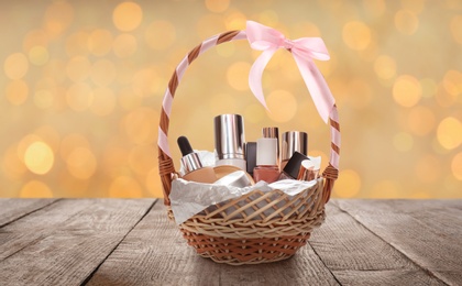 Image of Wicker basket full of cosmetic products on table against blurred festive lights 