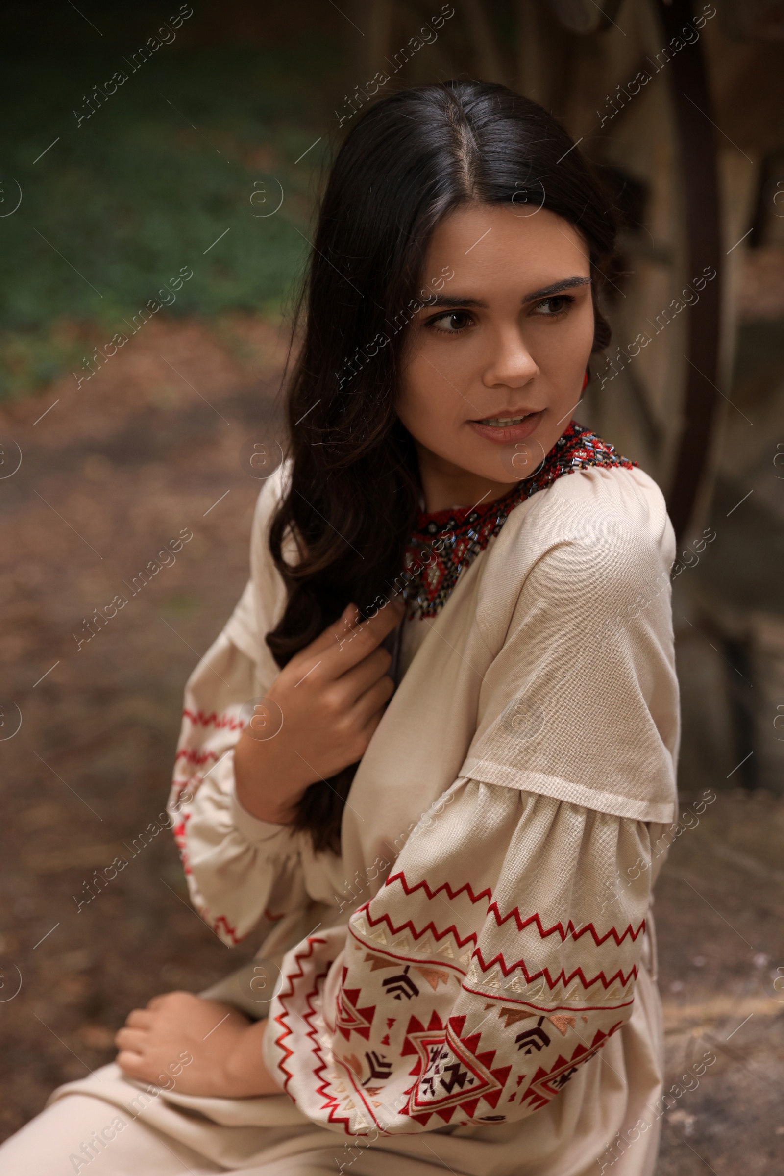 Photo of Beautiful woman wearing embroidered dress in village Ukrainian national clothes