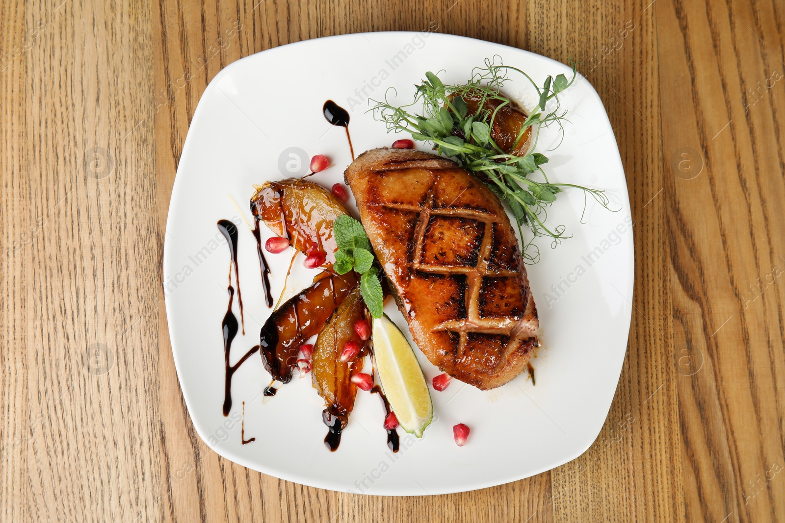 Photo of Delicious grilled duck breast served on wooden table, top view