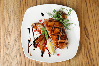 Photo of Delicious grilled duck breast served on wooden table, top view