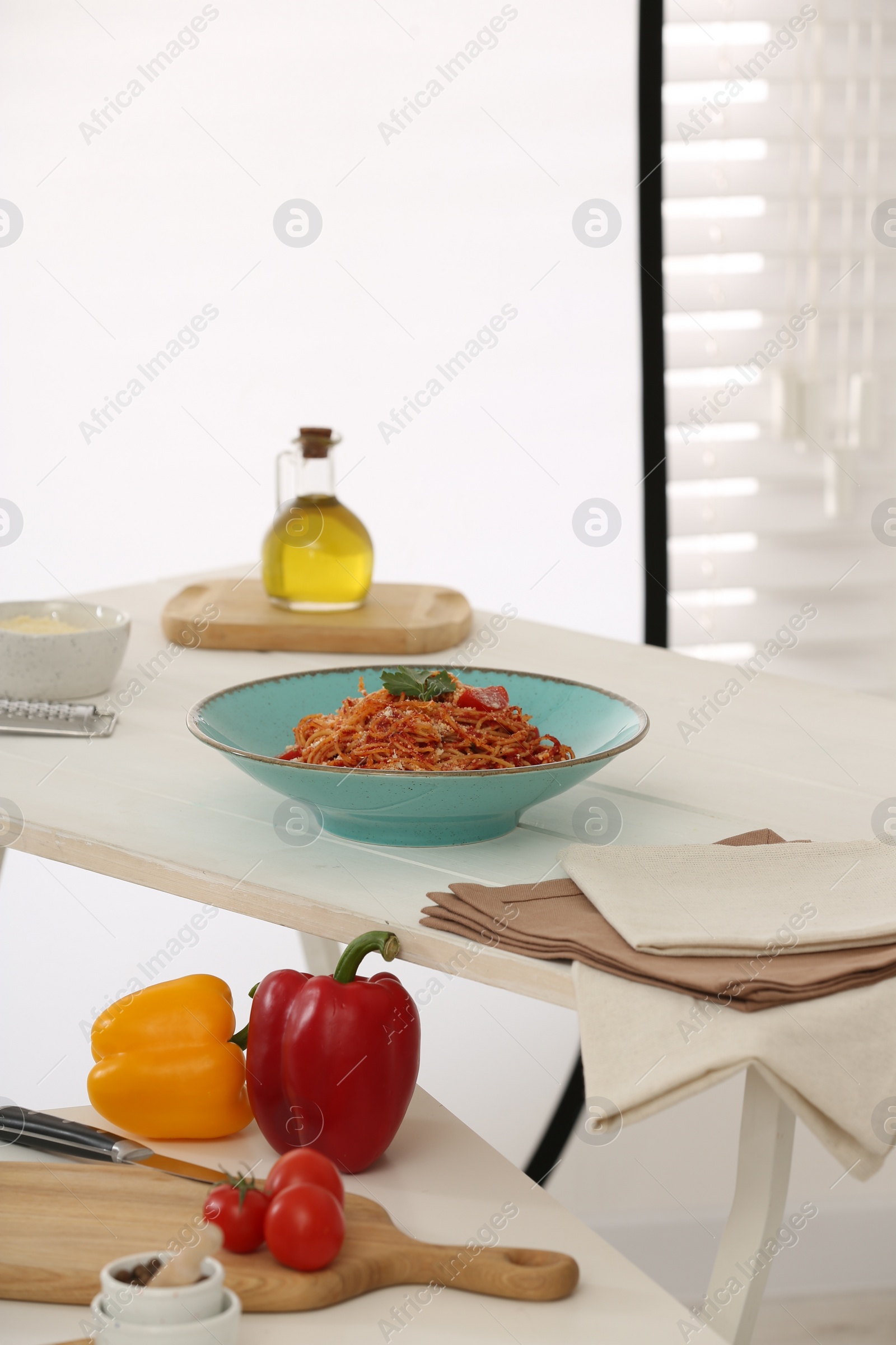 Photo of Professional equipment and composition with delicious spaghetti on white wooden table in studio. Food photography