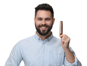 Handsome young man with mustache holding comb on white background