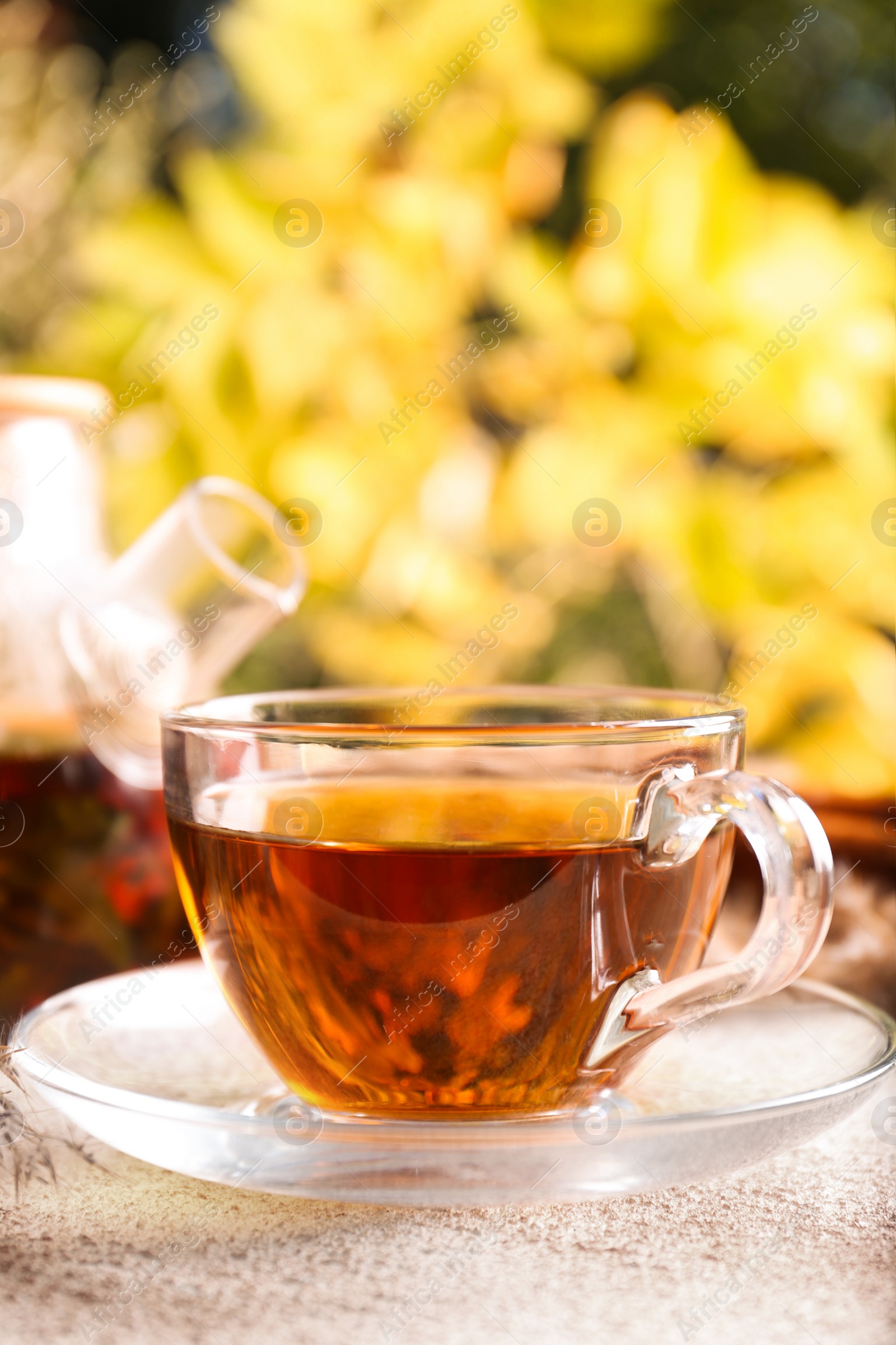 Photo of Hot tea on beige textured table outdoors, closeup. Autumn atmosphere