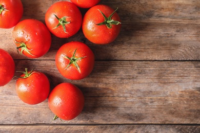 Fresh ripe tomatoes on wooden table, flat lay. Space for text