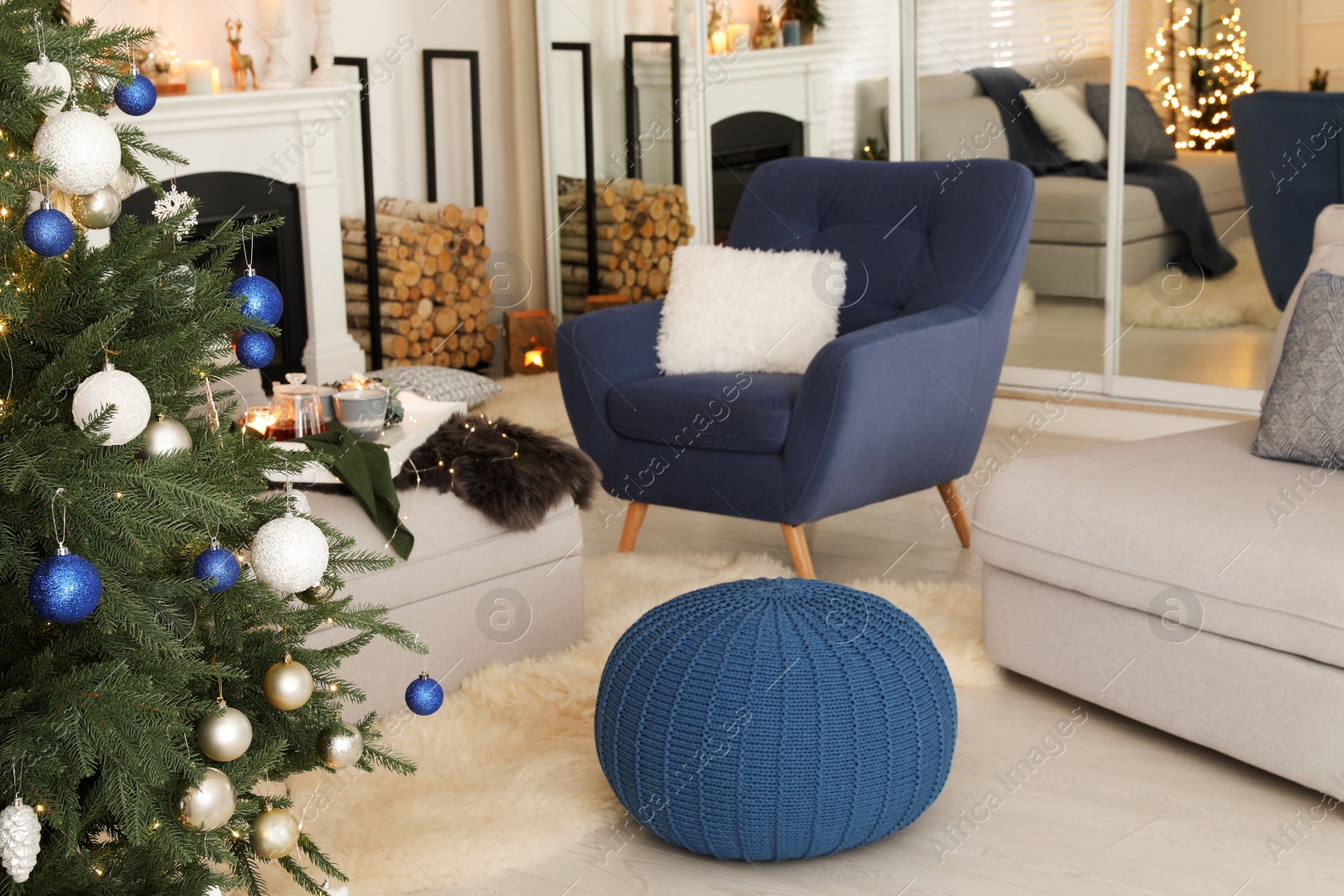 Photo of Cozy room interior with knitted pouf and beautiful Christmas tree