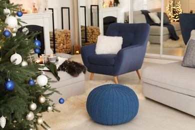 Photo of Cozy room interior with knitted pouf and beautiful Christmas tree