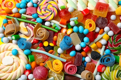 Many different yummy candies as background, top view