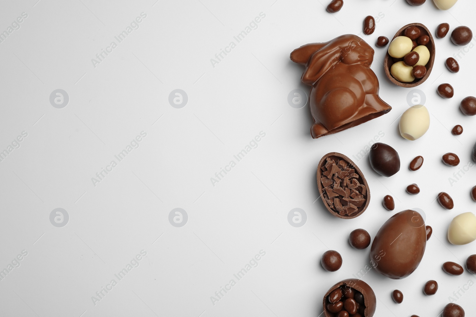 Photo of Flat lay composition with chocolate Easter eggs and space for text on white background