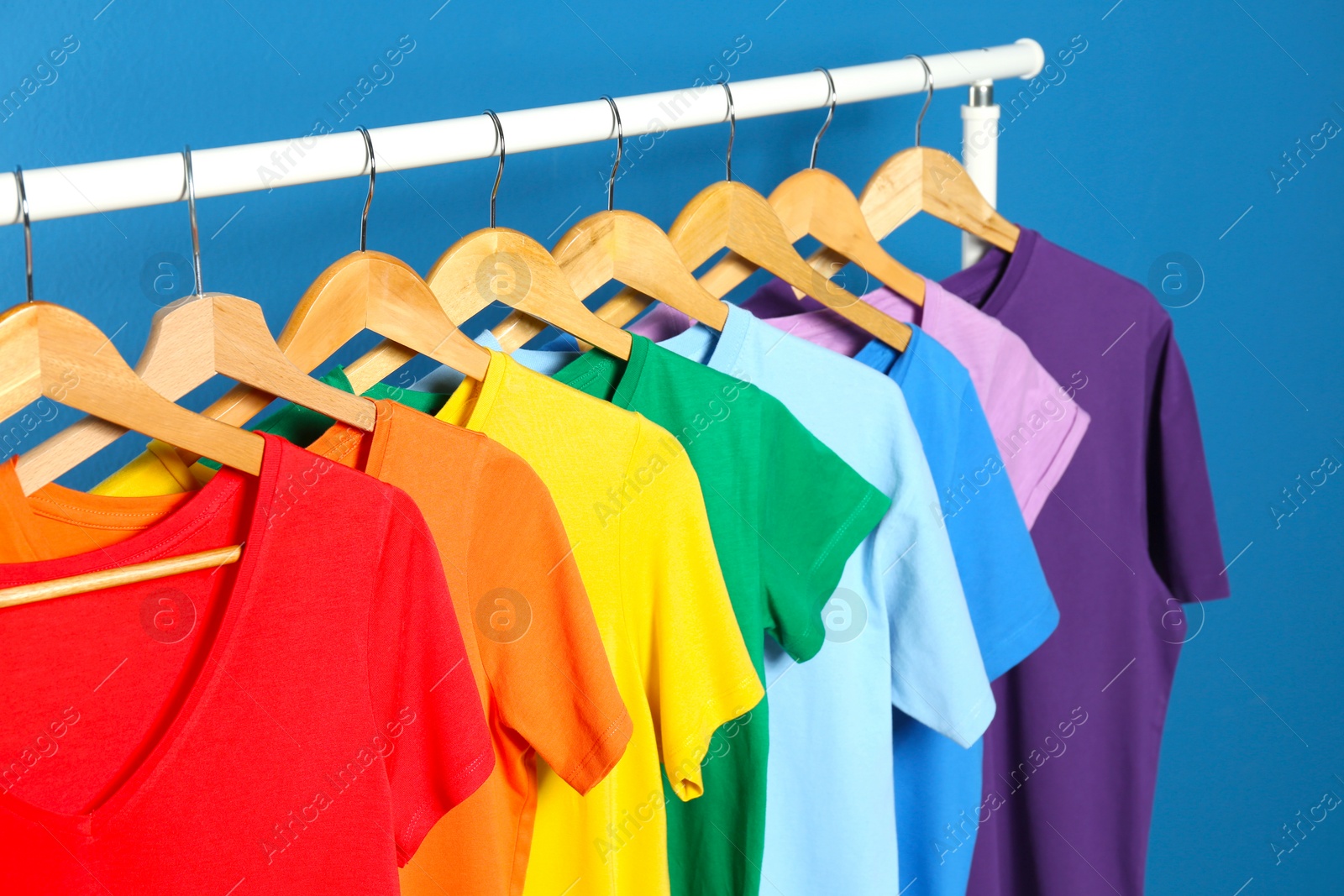 Photo of Bright clothes on blue background. Rainbow colors