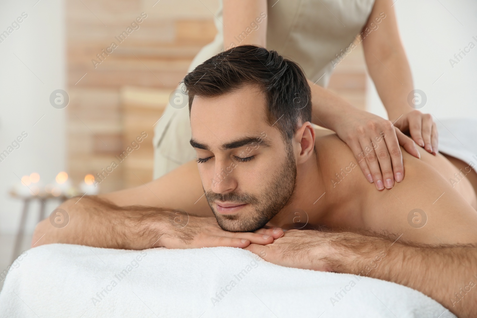 Photo of Handsome man receiving back massage in spa salon