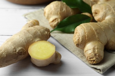 Photo of Fresh ginger with leaves on white wooden table