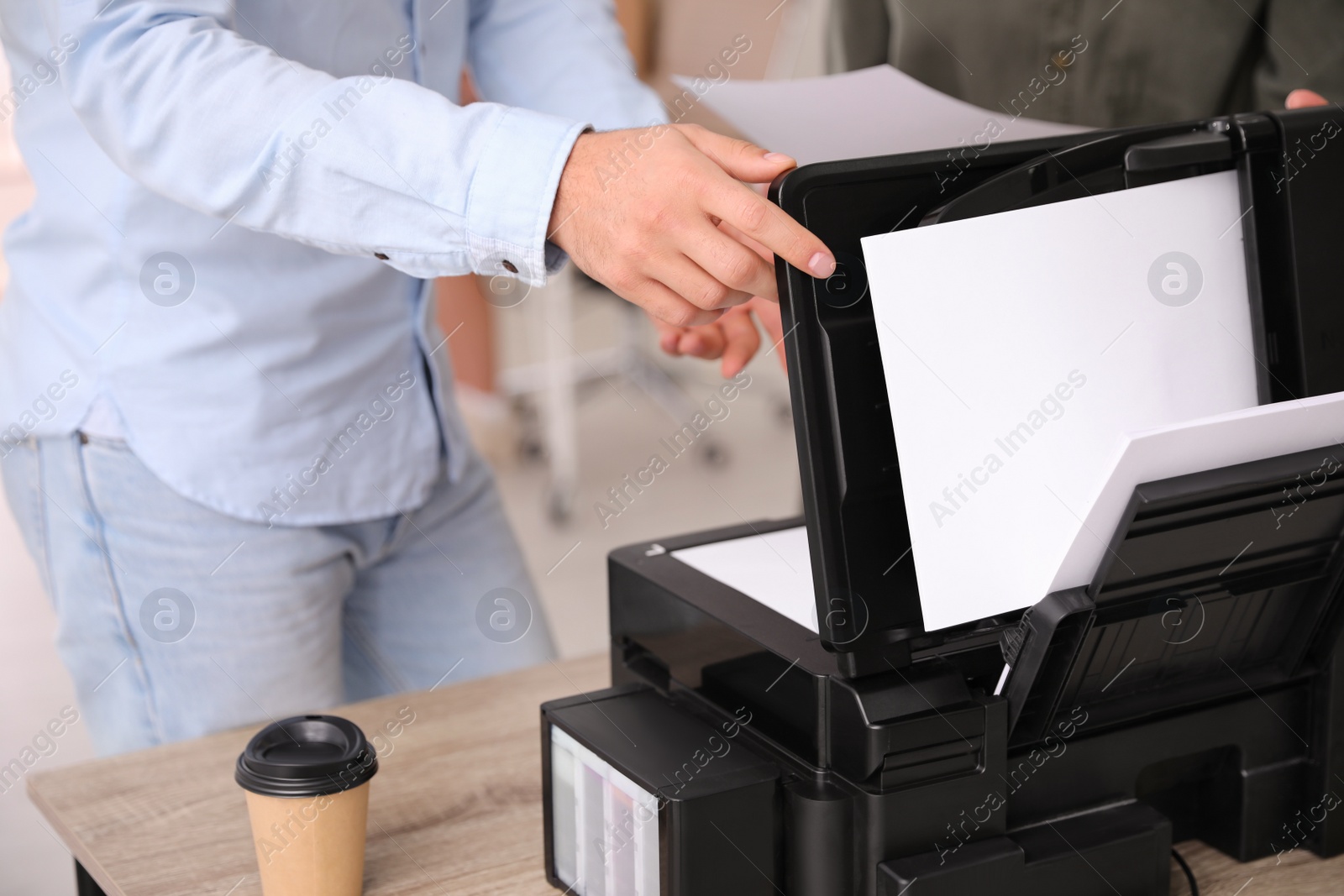 Photo of Employee using modern printer in office, closeup